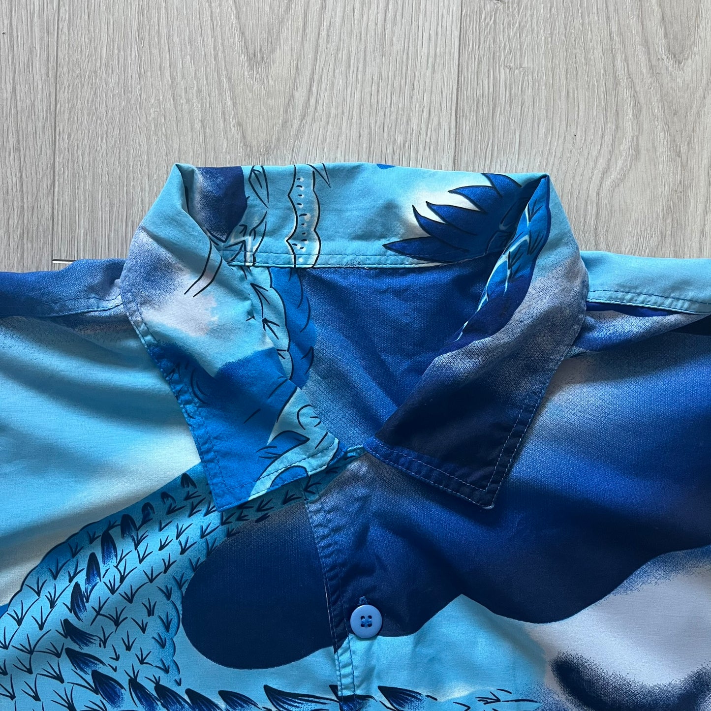 Blue shirt with floral pattern on a wooden surface