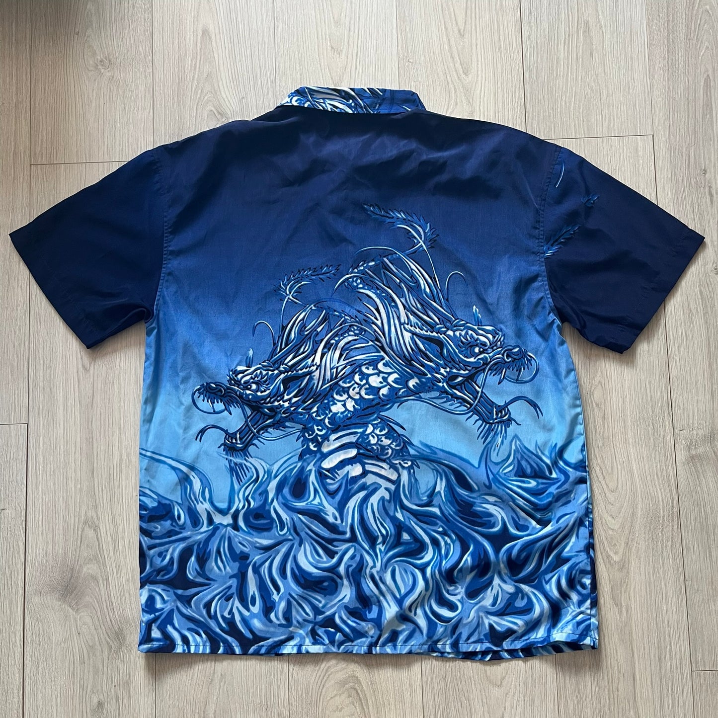 Blue fabric with white dragon design on a wooden surface