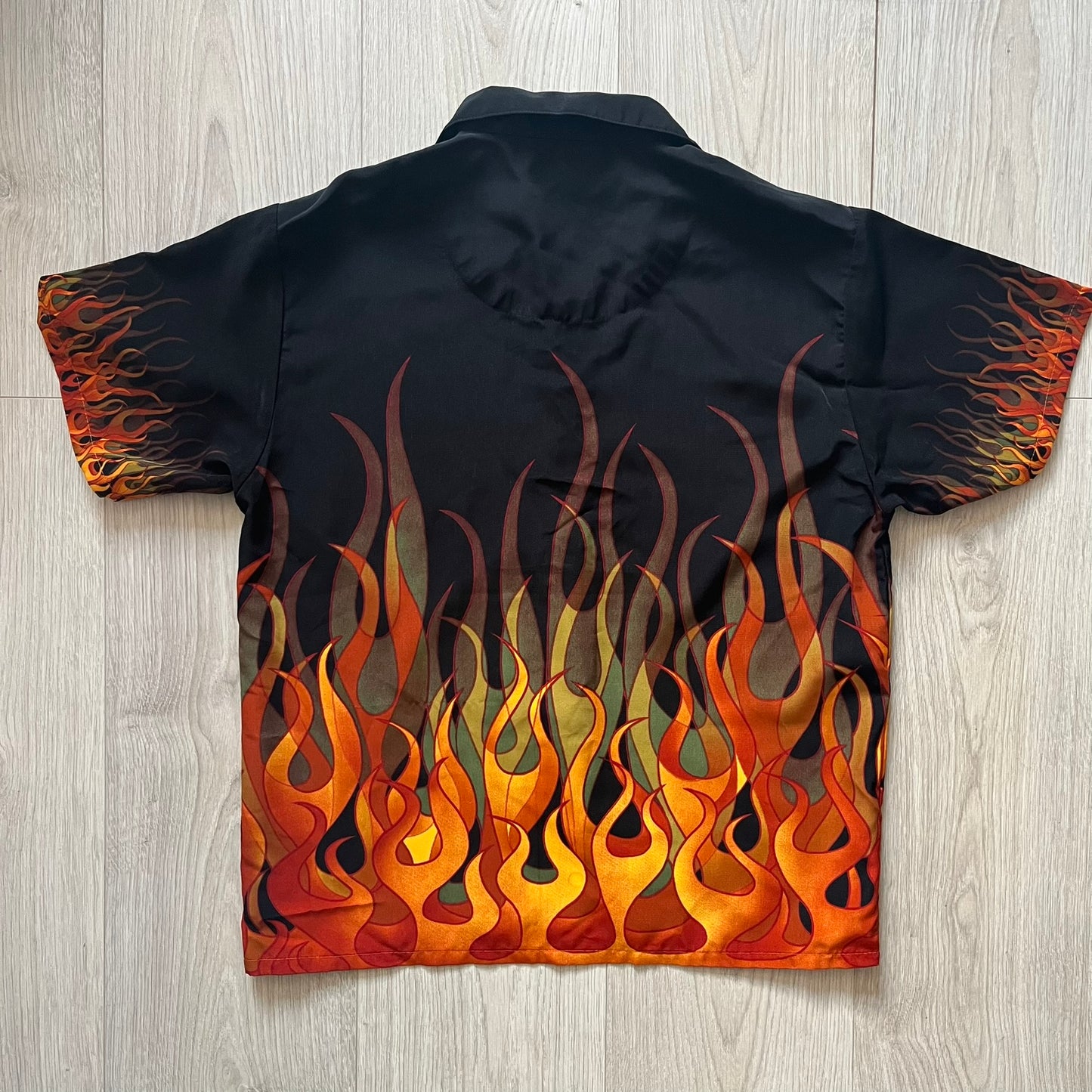 Black shirt with flame design on a wooden surface