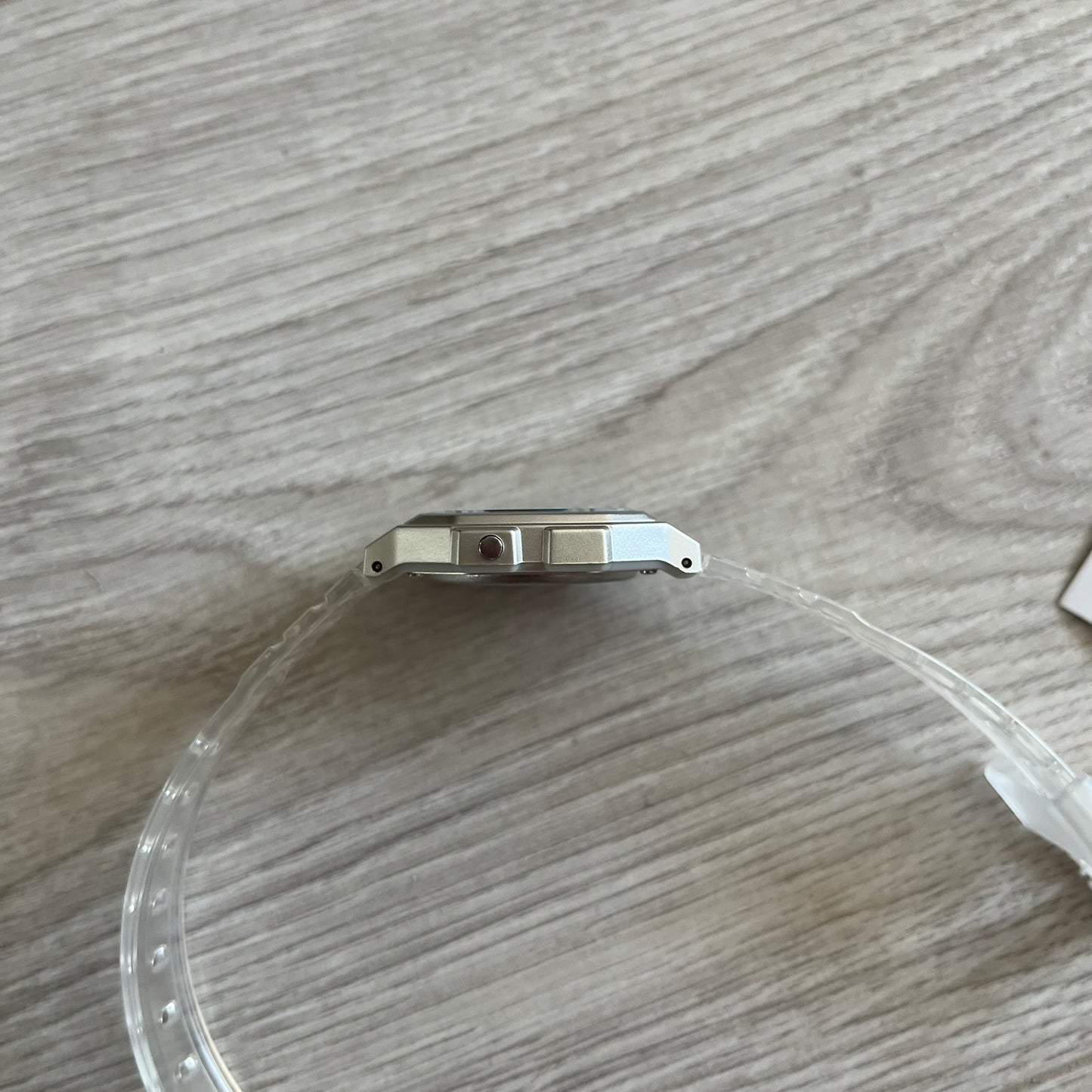Clear plastic cover on a watch case on a wooden surface