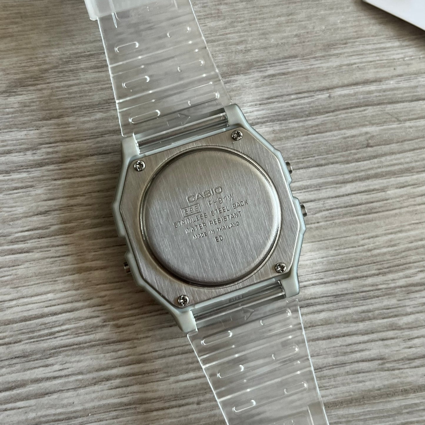 Casio watch with clear strap on a wooden surface