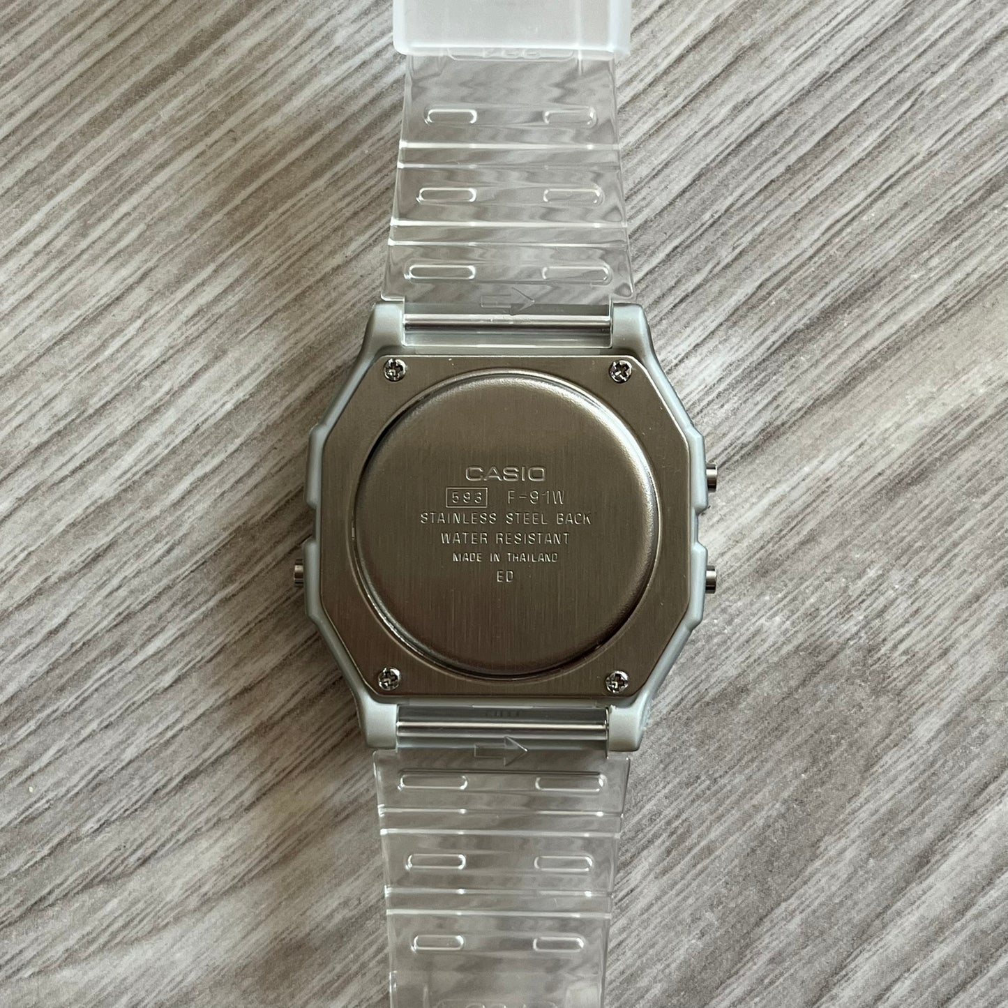 Casio watch with clear strap on a wooden surface