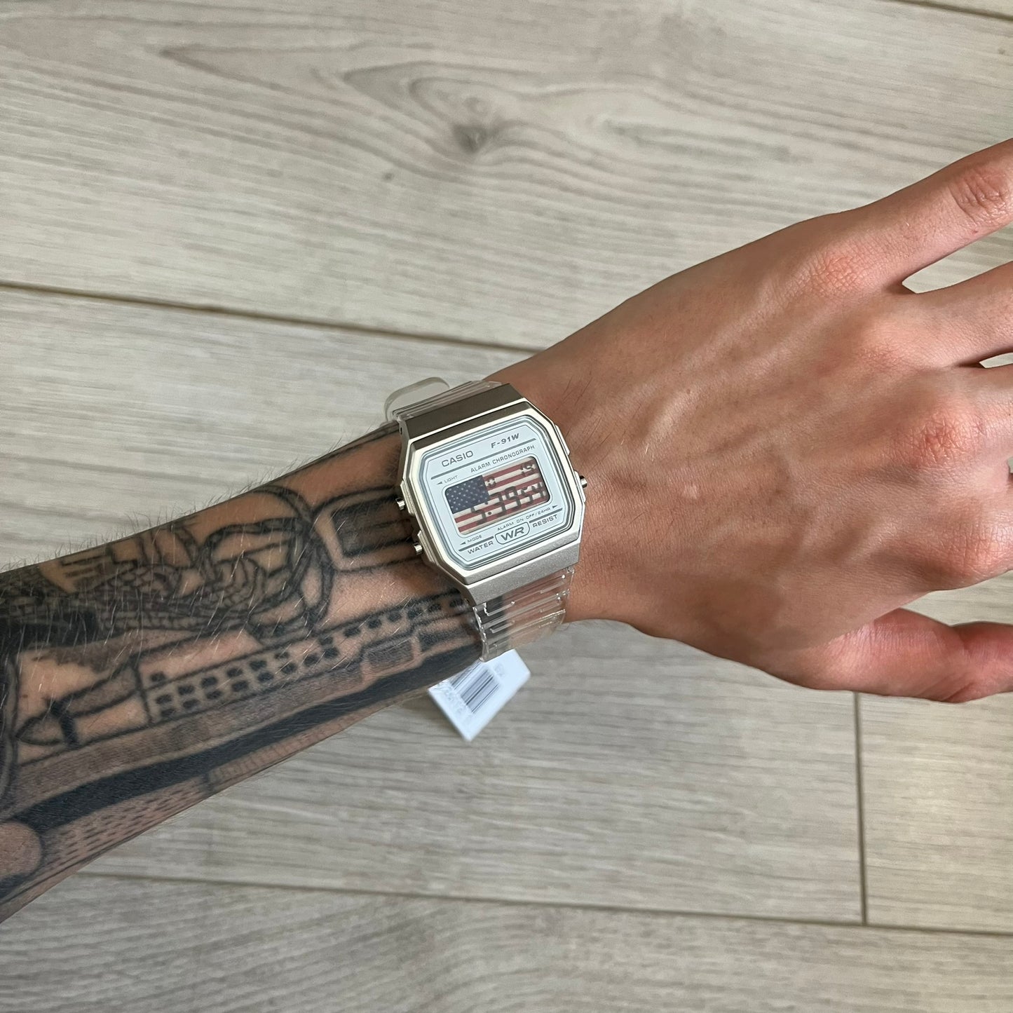 Hand wearing a watch with a wooden background