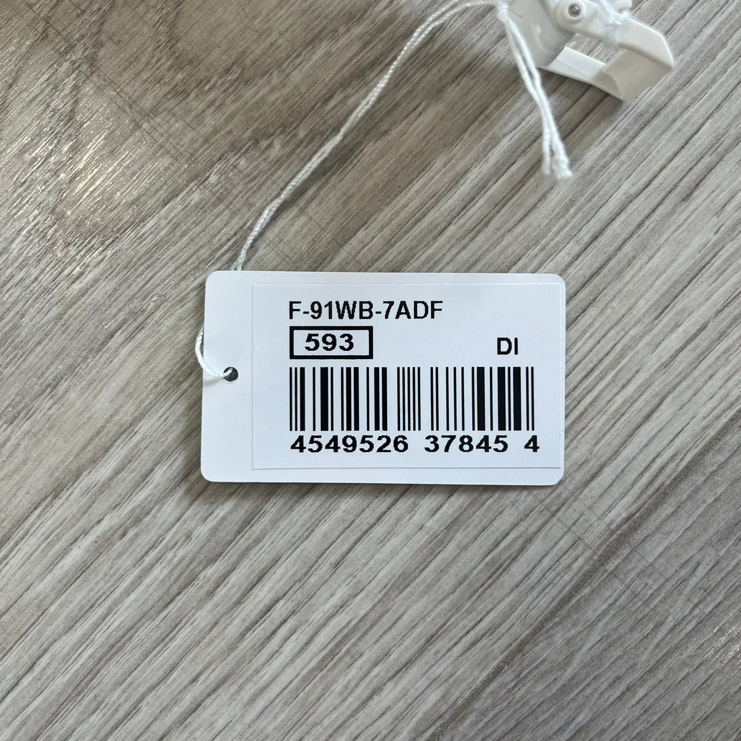 Product tag with barcode and text on a wooden surface