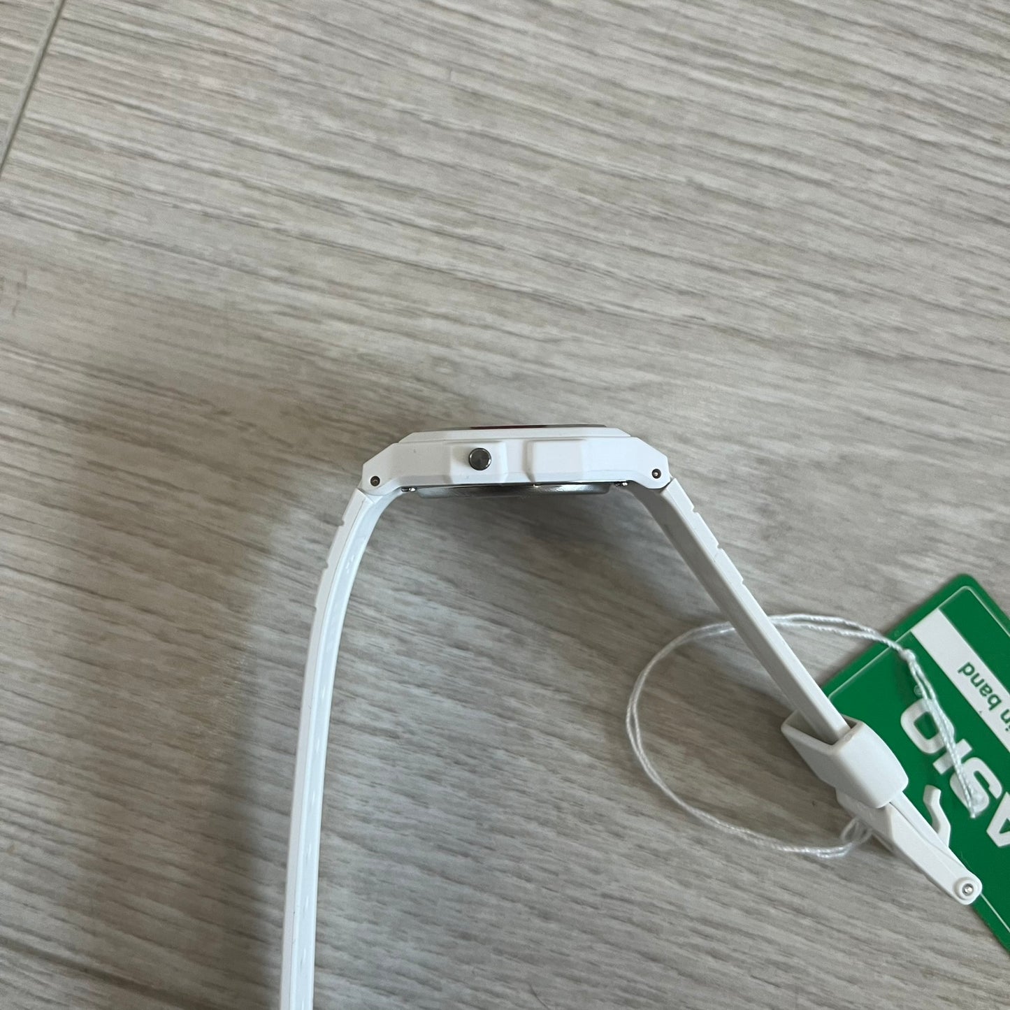 White USB cable on a wooden surface with a green label