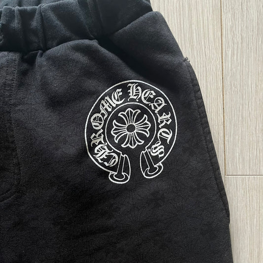 Black jacket with a white embroidered logo on a wooden floor background