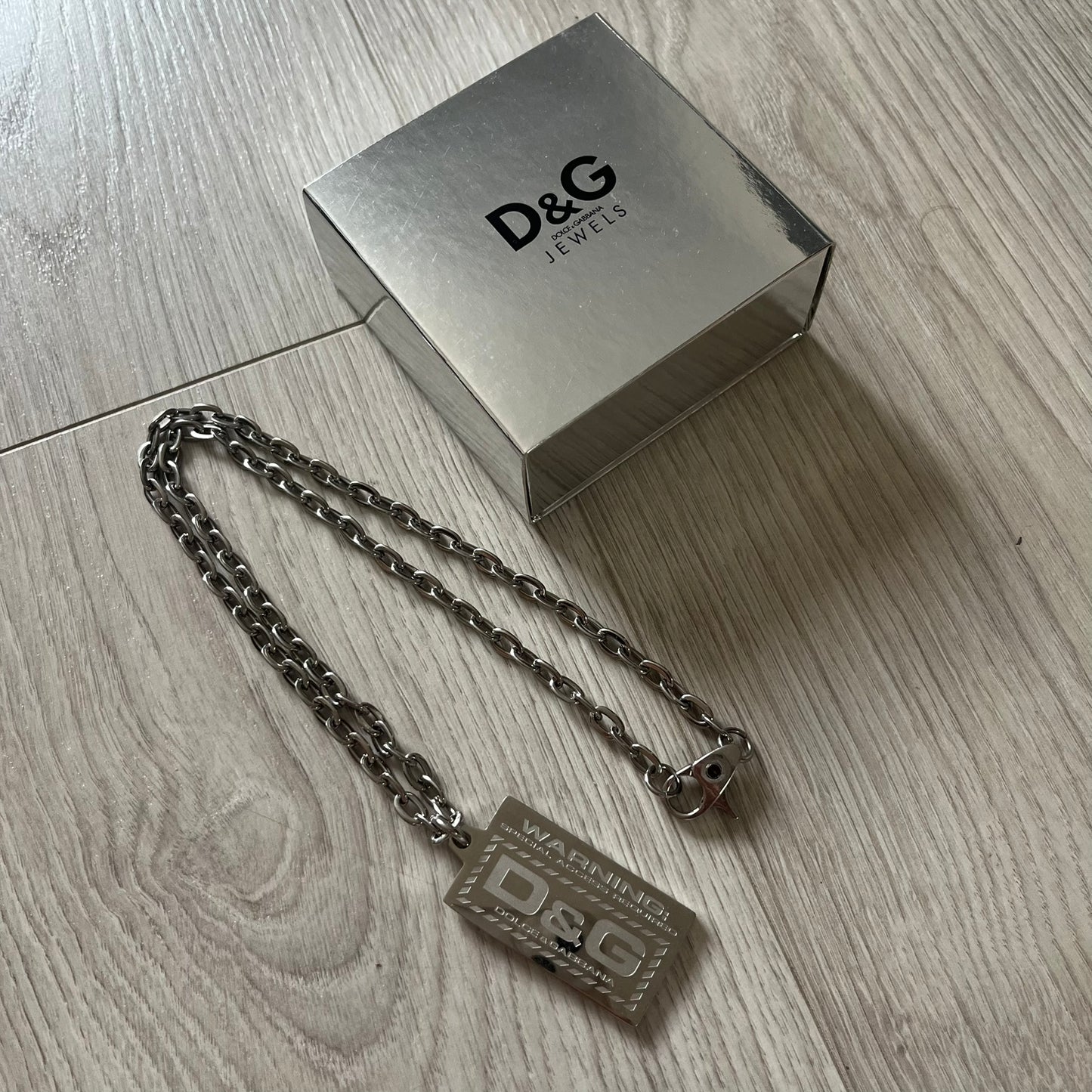 D&G jewelry box with chain on a wooden surface