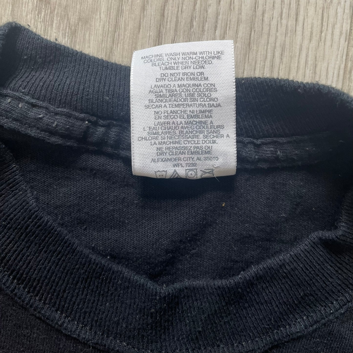 Black sweater with a care label on a textured surface