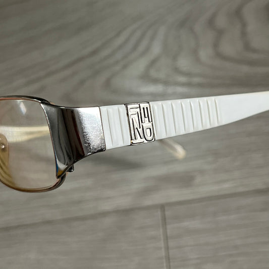 Close-up of a silver spoon with a logo on a wooden surface
