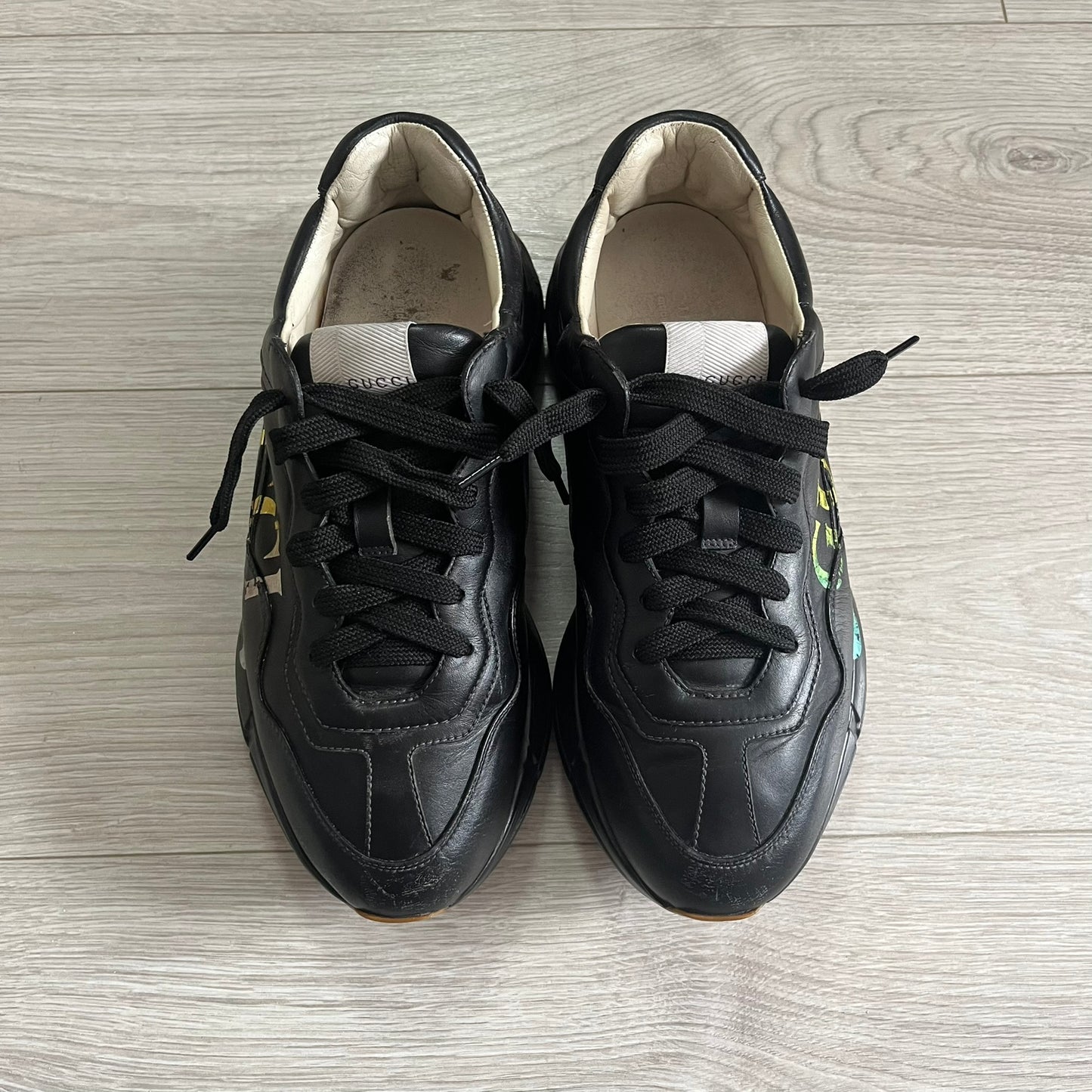 Pair of black sneakers on a light wooden floor