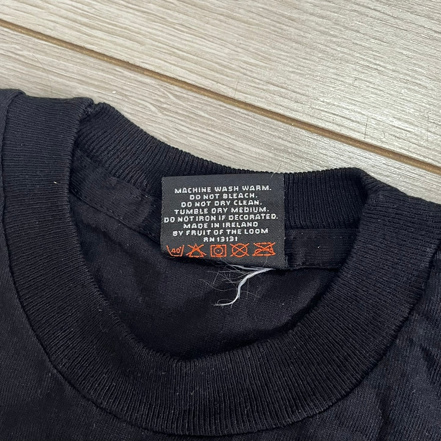 Black sweater with a label on a wooden surface