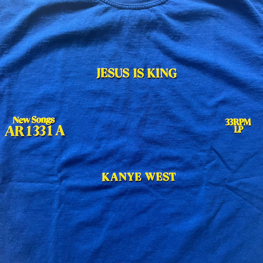 Blue t-shirt with yellow text about Kanye West's album 'Jesus Is King'.