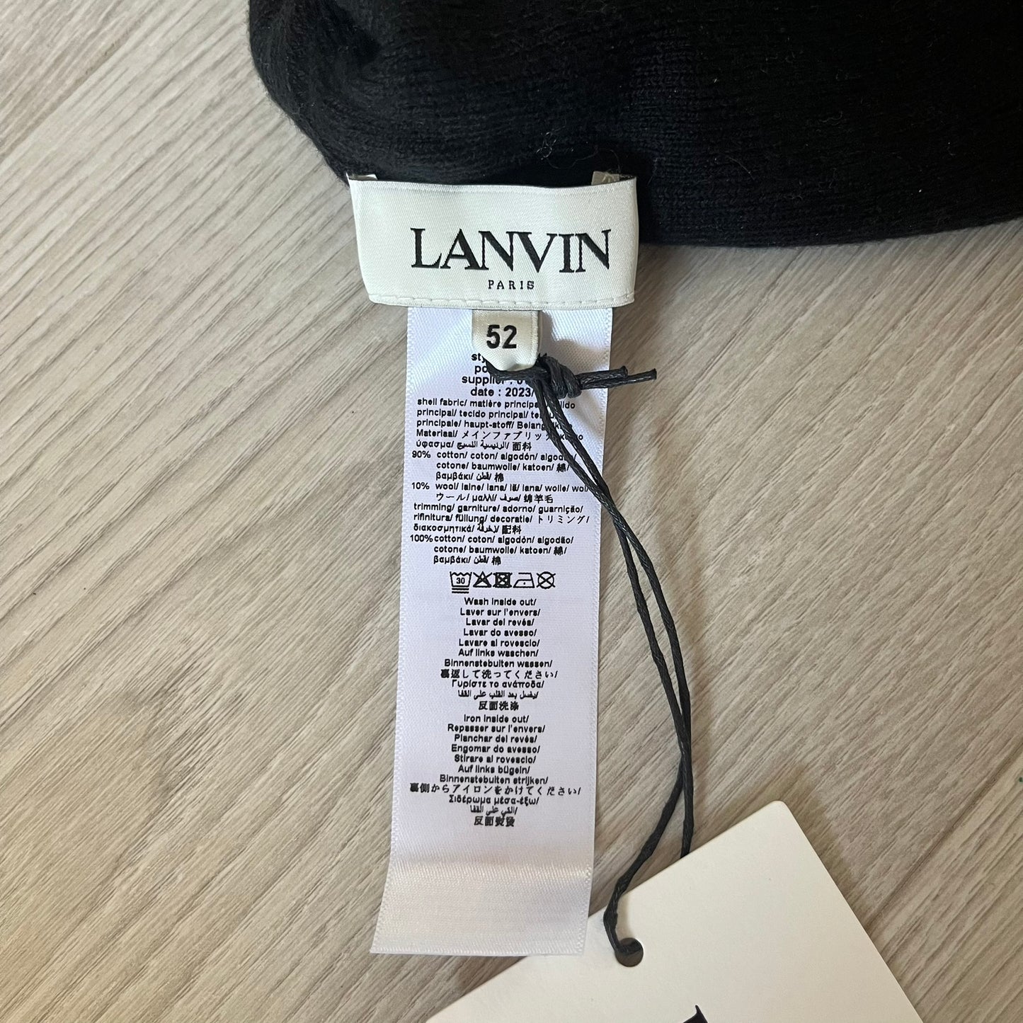 Black sock with a Lanvin tag on a wooden surface