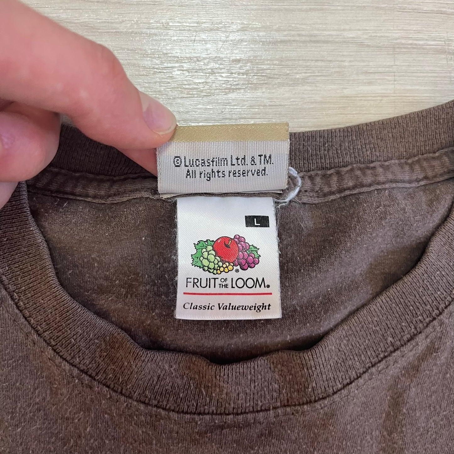 Close-up of a brown garment with 'Fruit of the Loom' and 'Lucasfilm' labels