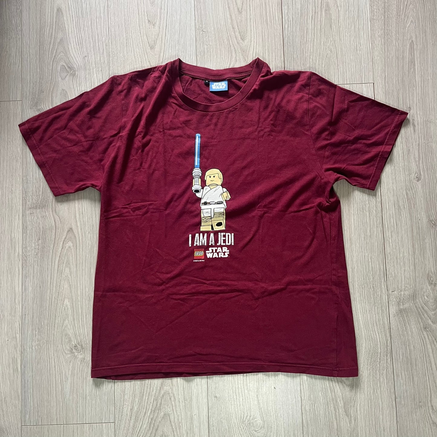 Maroon t-shirt with 'I Am a Jedi' graphic on a wooden surface
