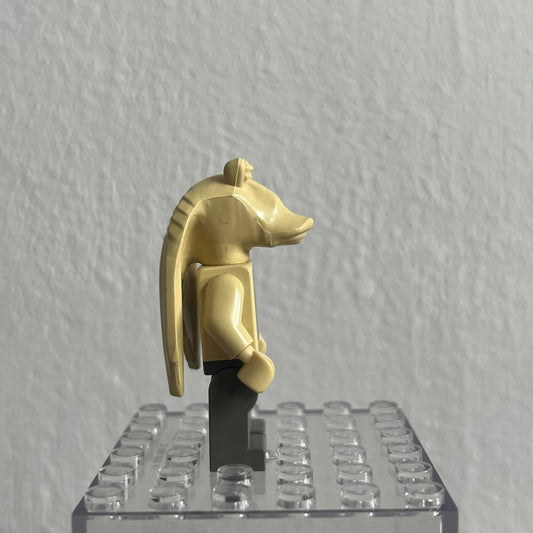 Gold-colored animal figure on a clear baseplate against a gray background