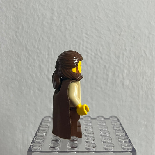 LEGO figure with brown hair and outfit on a clear baseplate against a white background