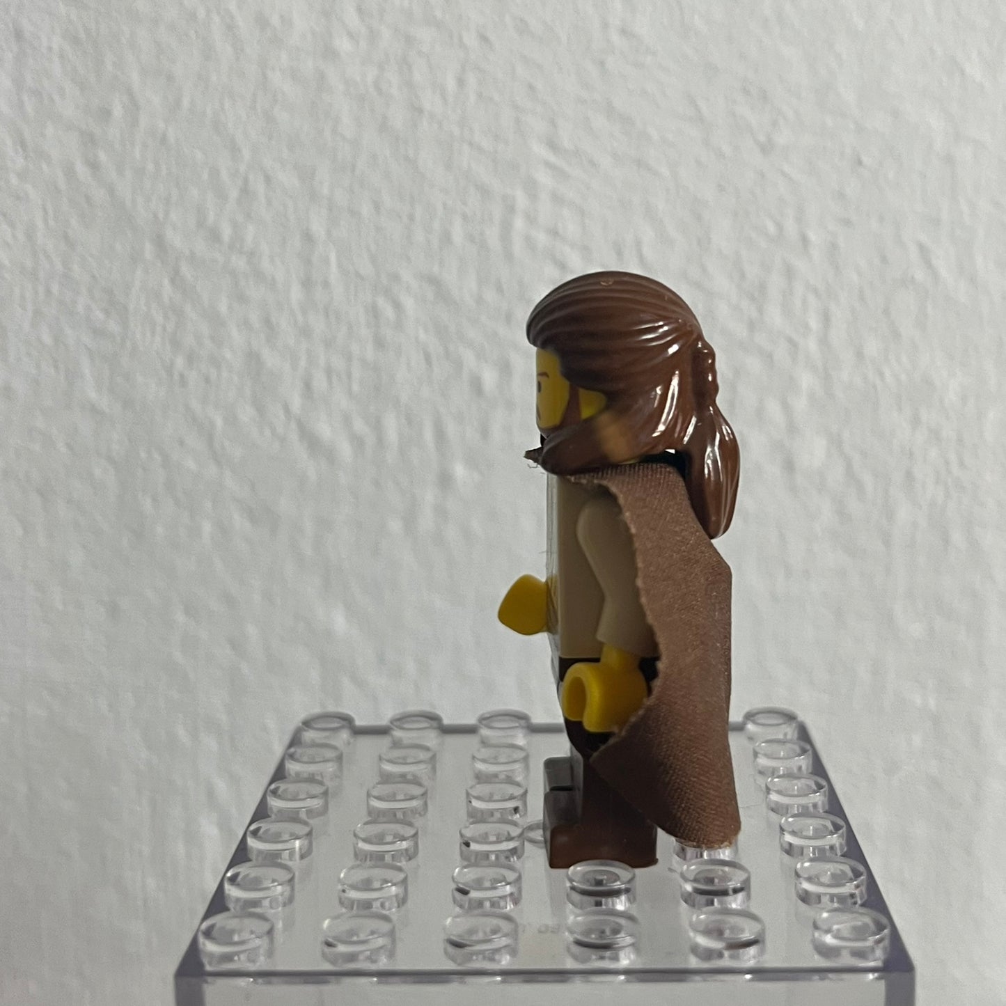 LEGO minifigure on a clear baseplate against a white wall