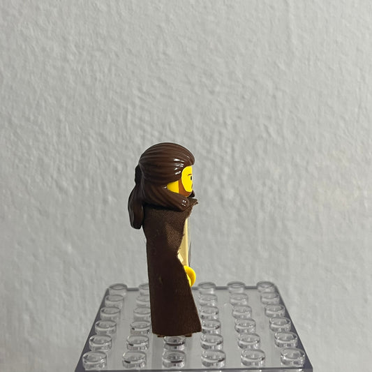LEGO minifigure head with brown hair and beard on a clear baseplate against a gray background