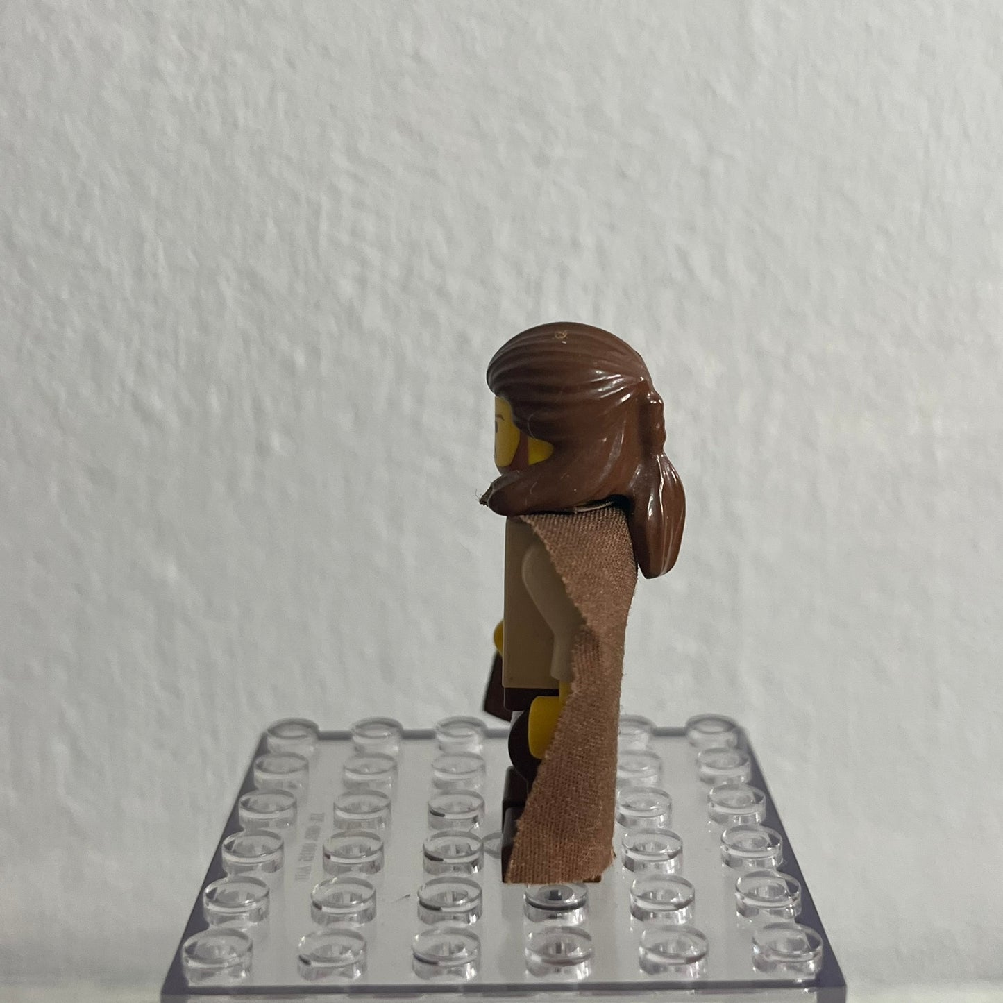 Toy figure on a clear baseplate against a white background