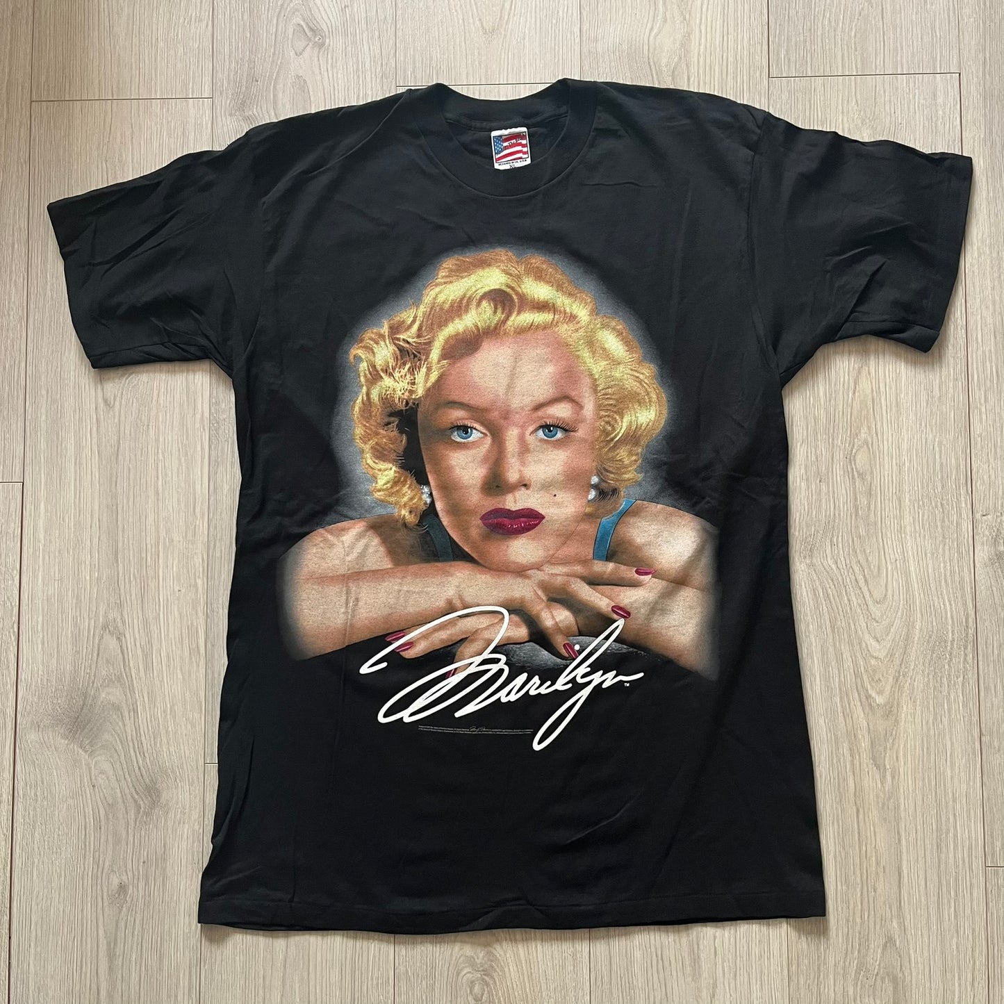 Black t-shirt with a graphic of a famous actress and signature on a wooden surface