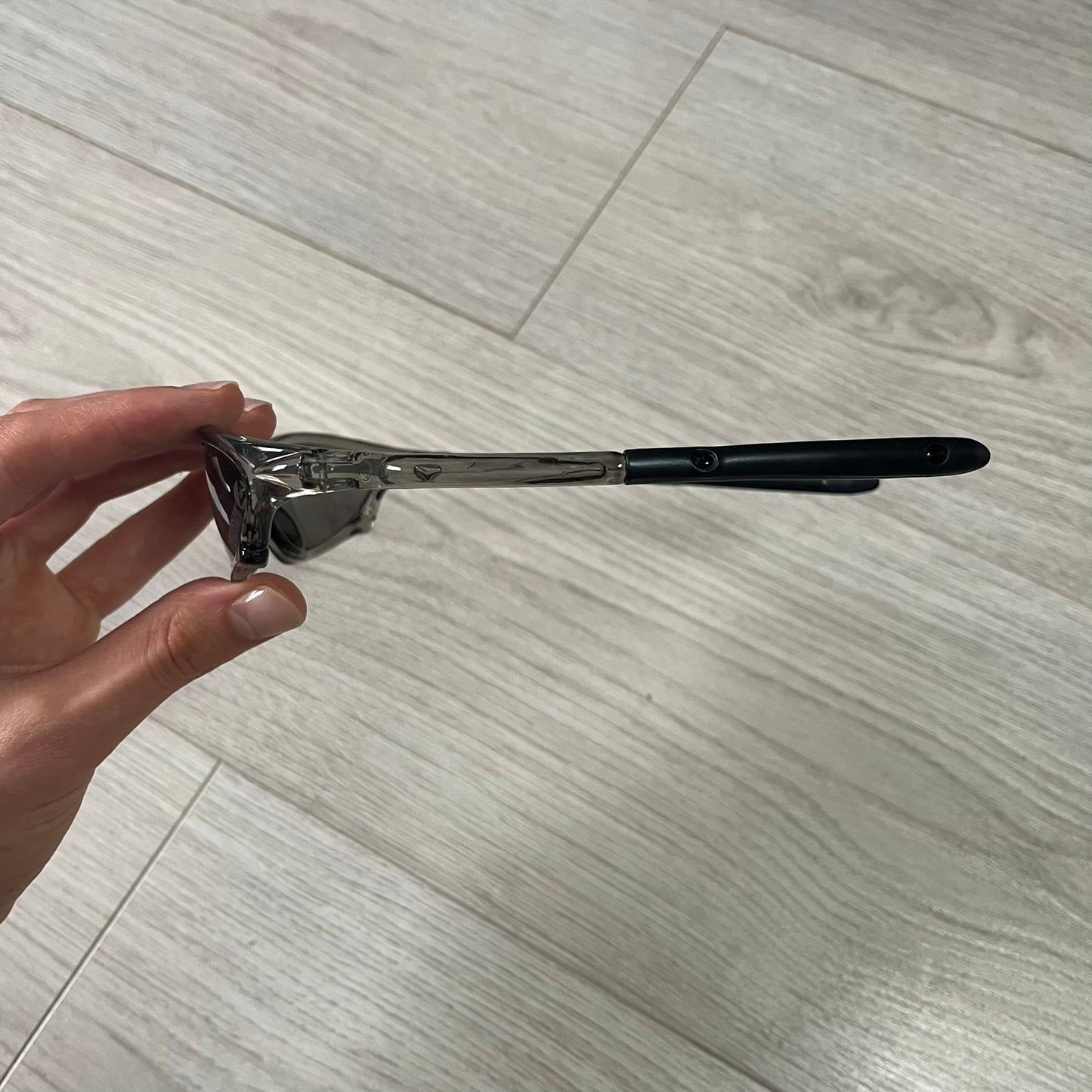 Hair curler held by a hand on a light wooden floor