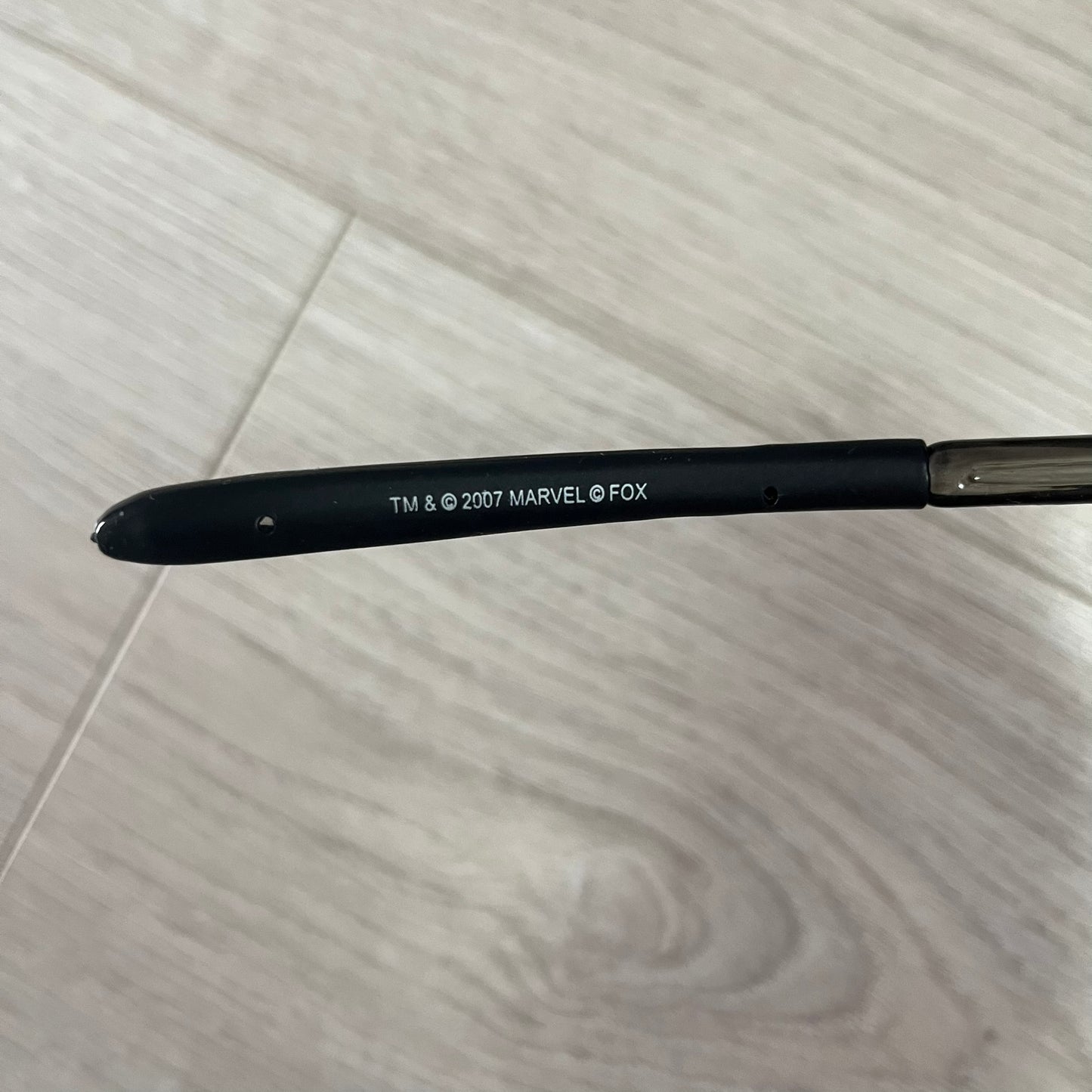 Black pen with Marvel and Fox branding on a light wooden surface