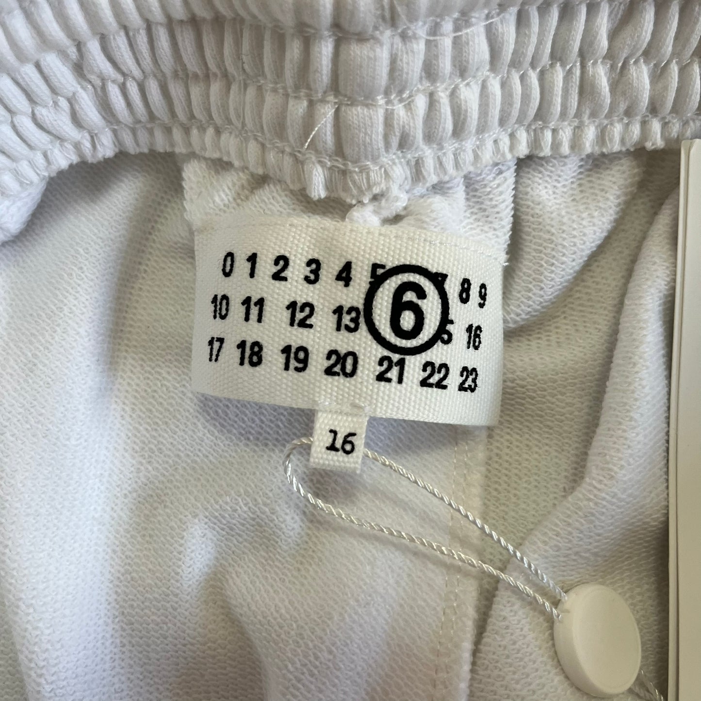 Close-up of a clothing tag on a textured fabric background