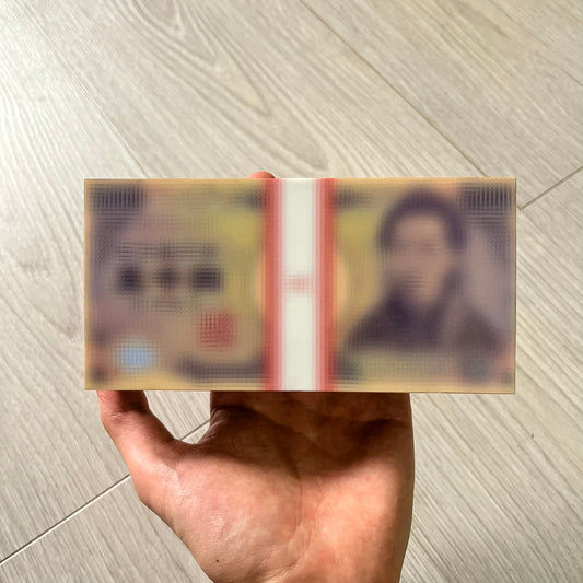 Hand holding a folded banknote with a blurred face on a wooden floor background
