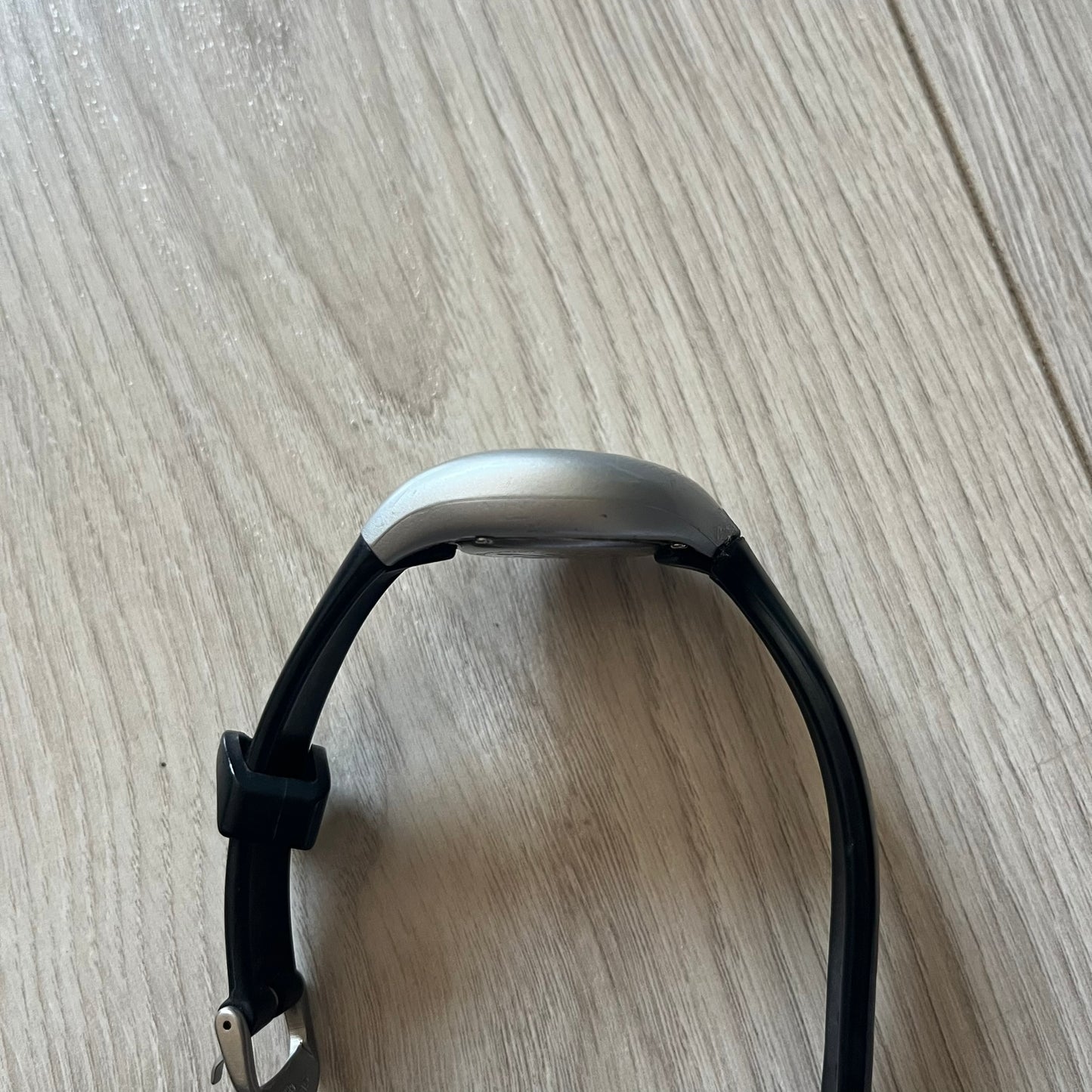 Black and silver smartwatch on a wooden surface