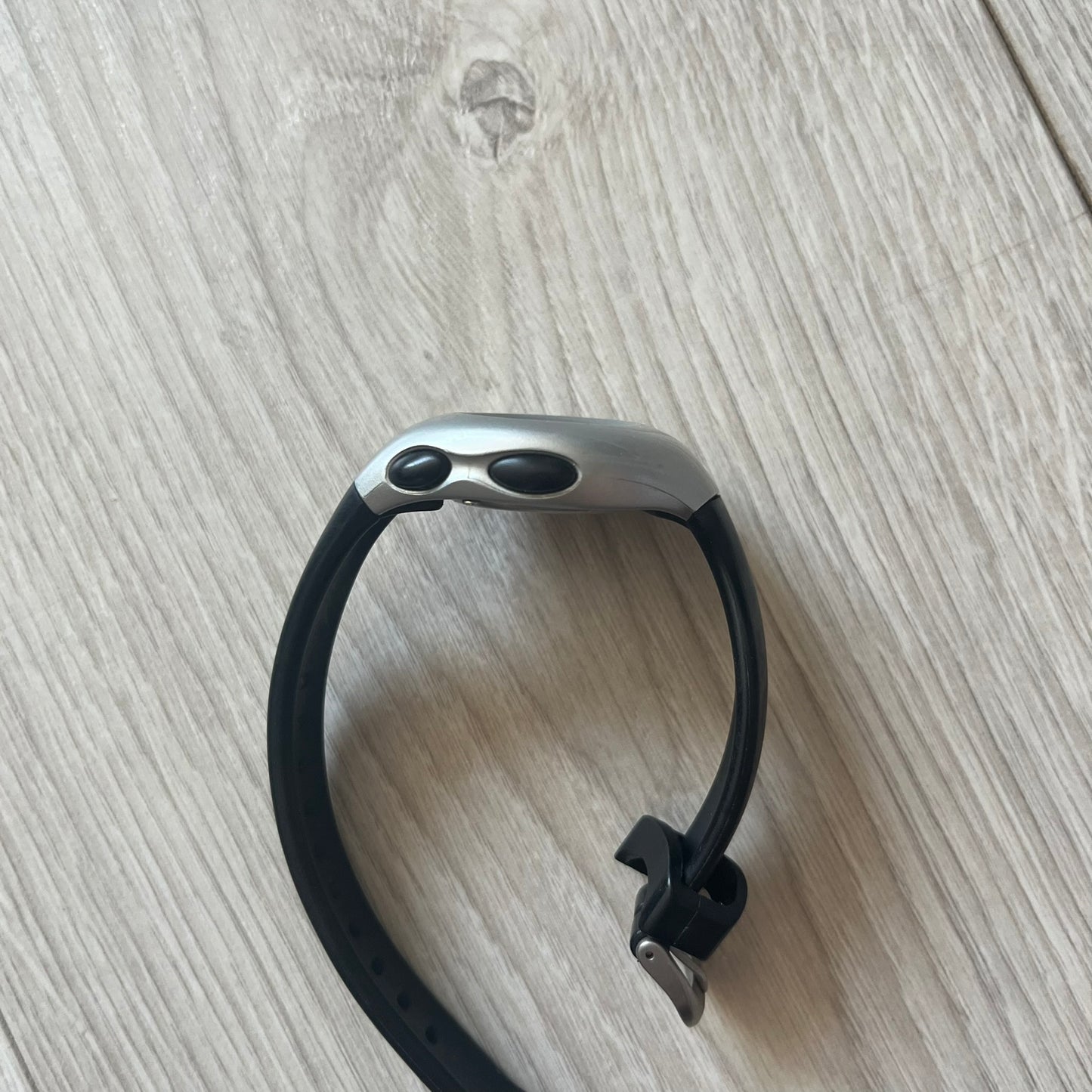 Black and silver device on a light wooden surface