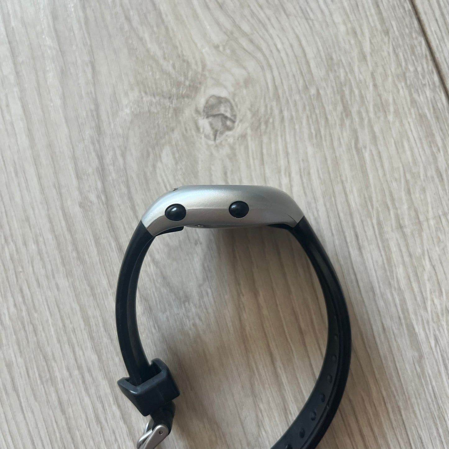 Black smartwatch on a light wooden surface
