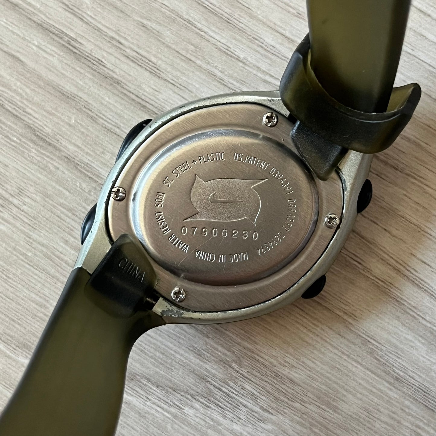 Close-up of a watch case with branding on a wooden surface