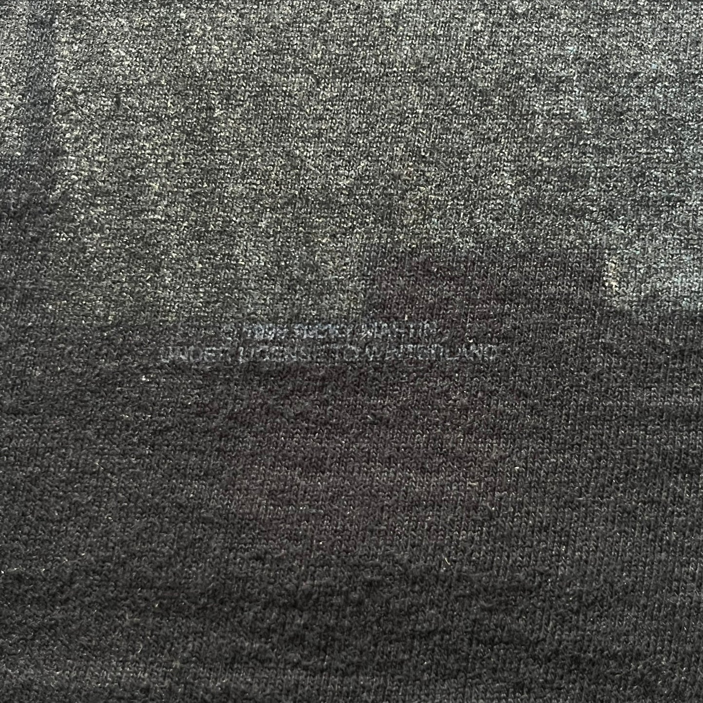 Close-up of a textured fabric with a brand logo in the center.