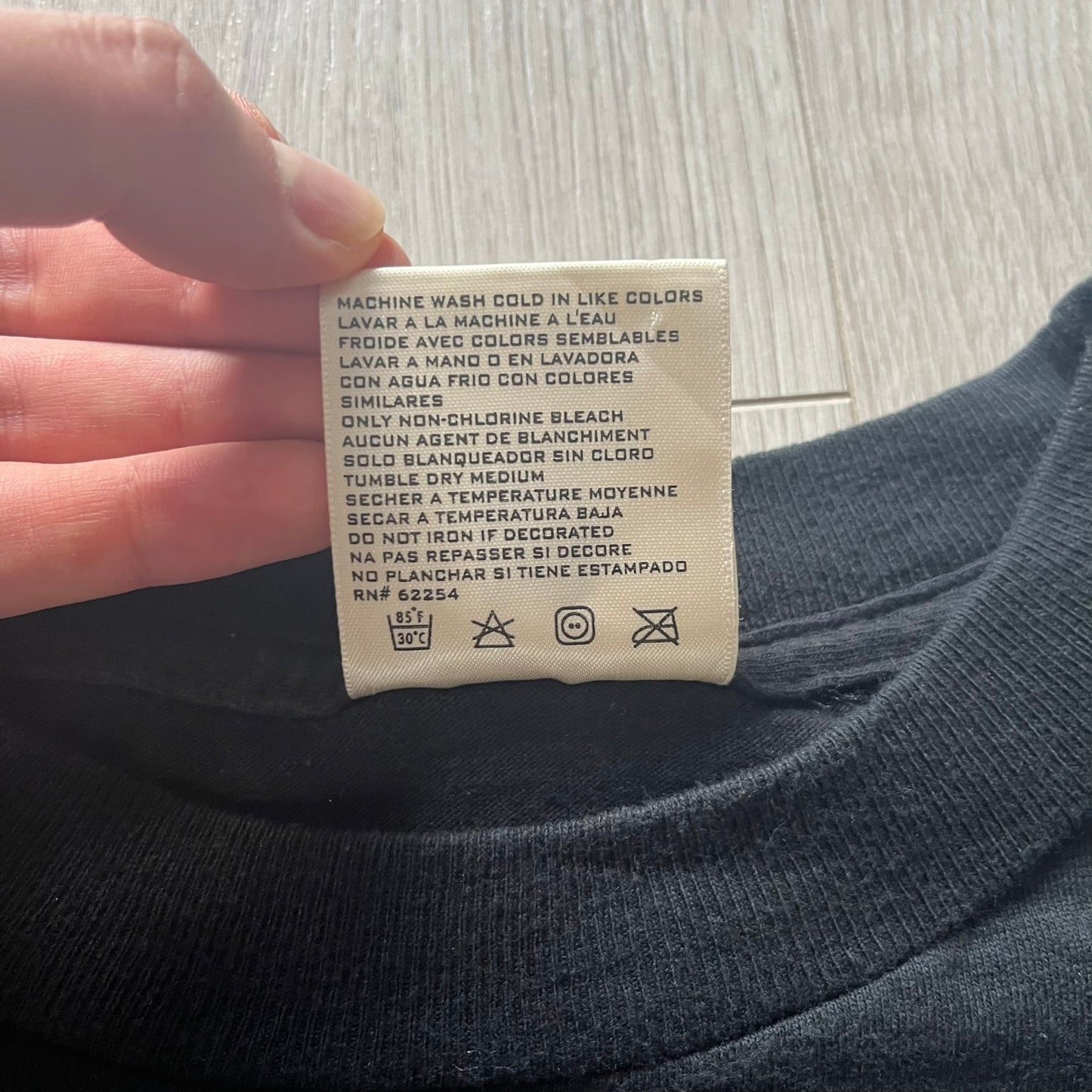 Clothing label on a dark fabric with washing instructions.