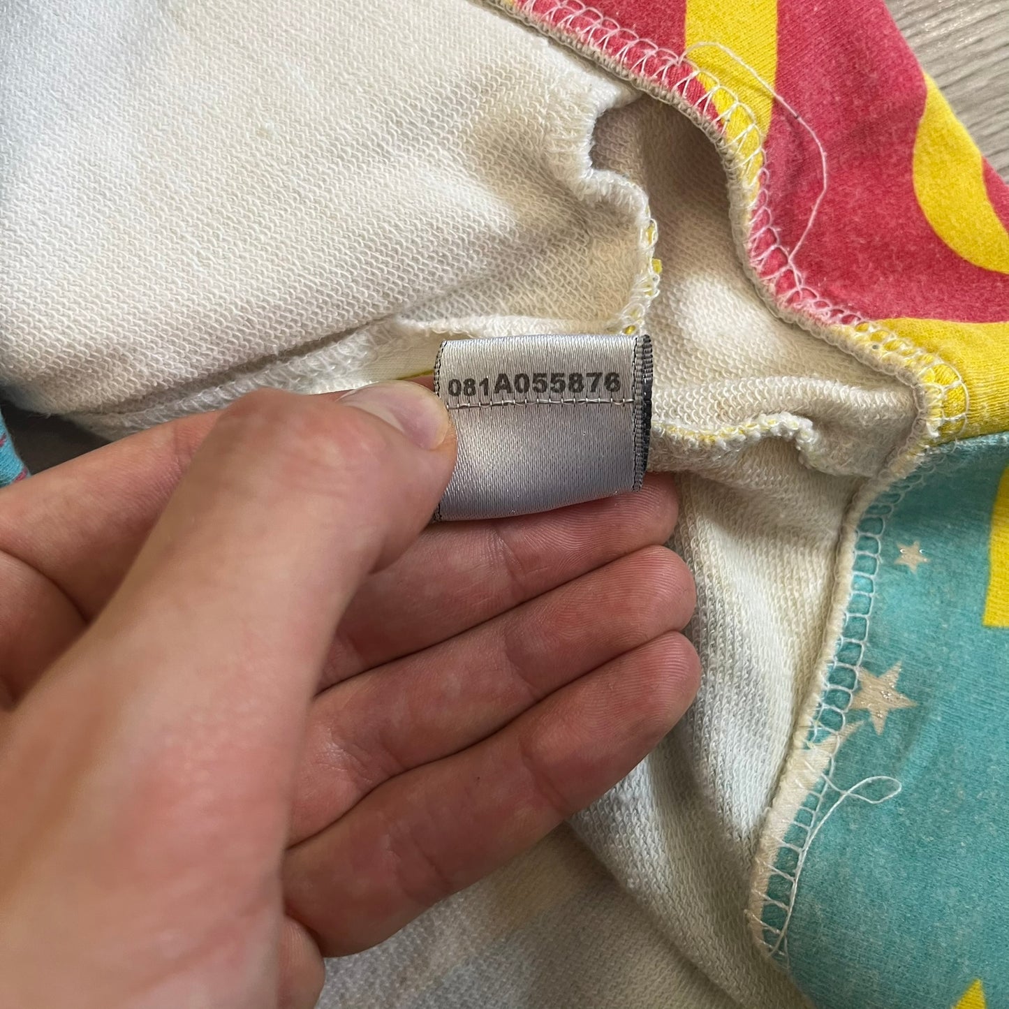 Close-up of a label on a piece of fabric with a hand holding it.