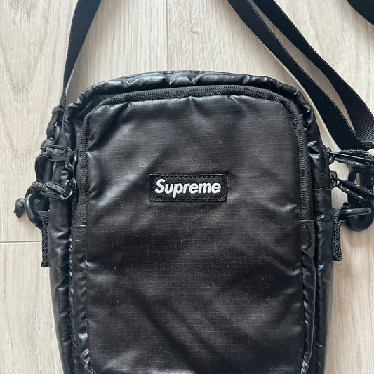 Black Supreme bag on a light wood surface