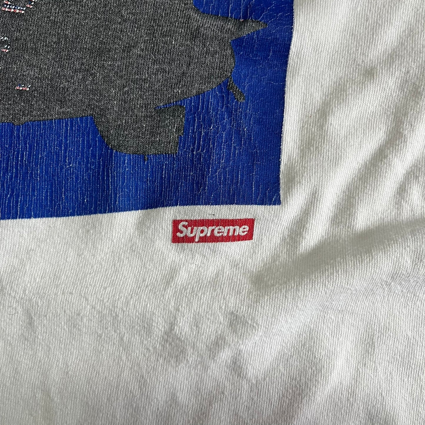 Gray sweatshirt with a red 'Supreme' logo on a blue and gray background