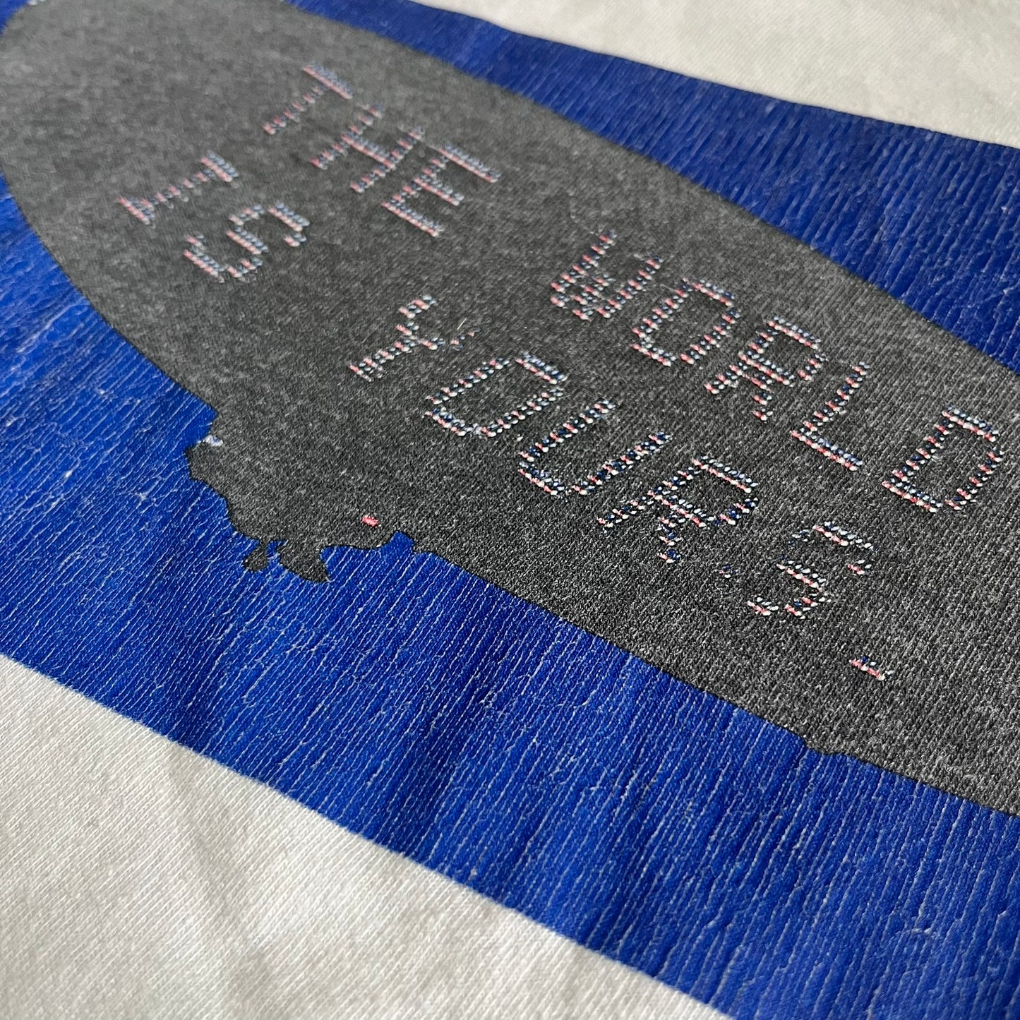 Textured surface with 'THE WORLD IS YOURS' embossed on a blue and gray background