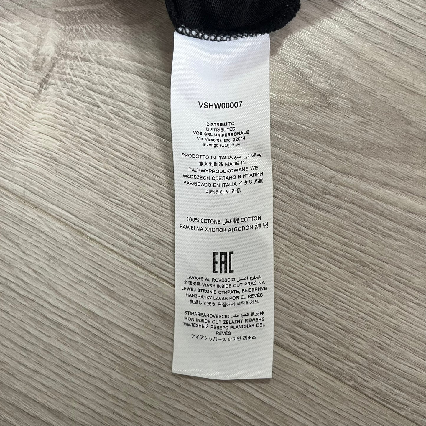 Clothing label with text on a wooden surface