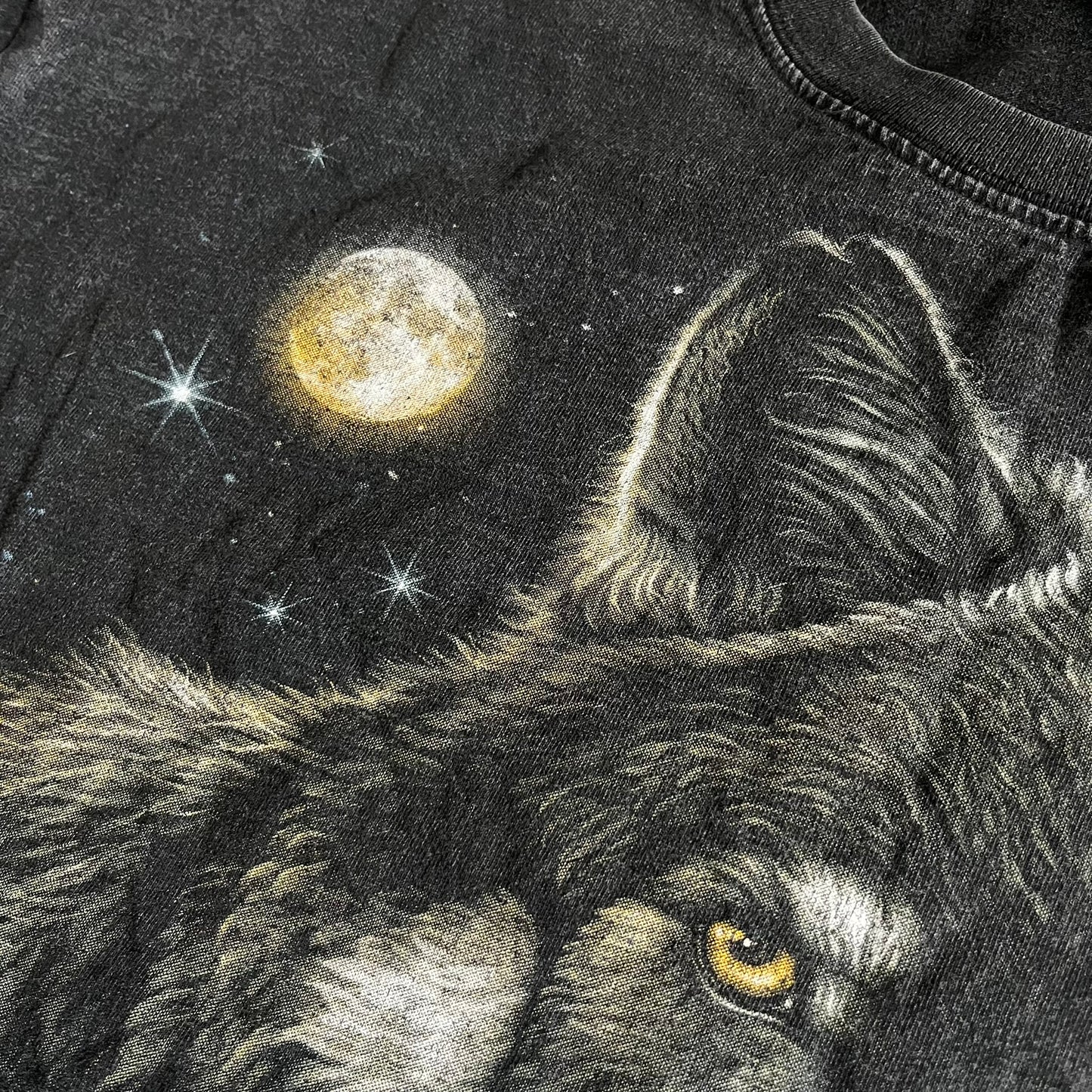 Black t-shirt with a graphic of a wolf howling at the moon and stars.