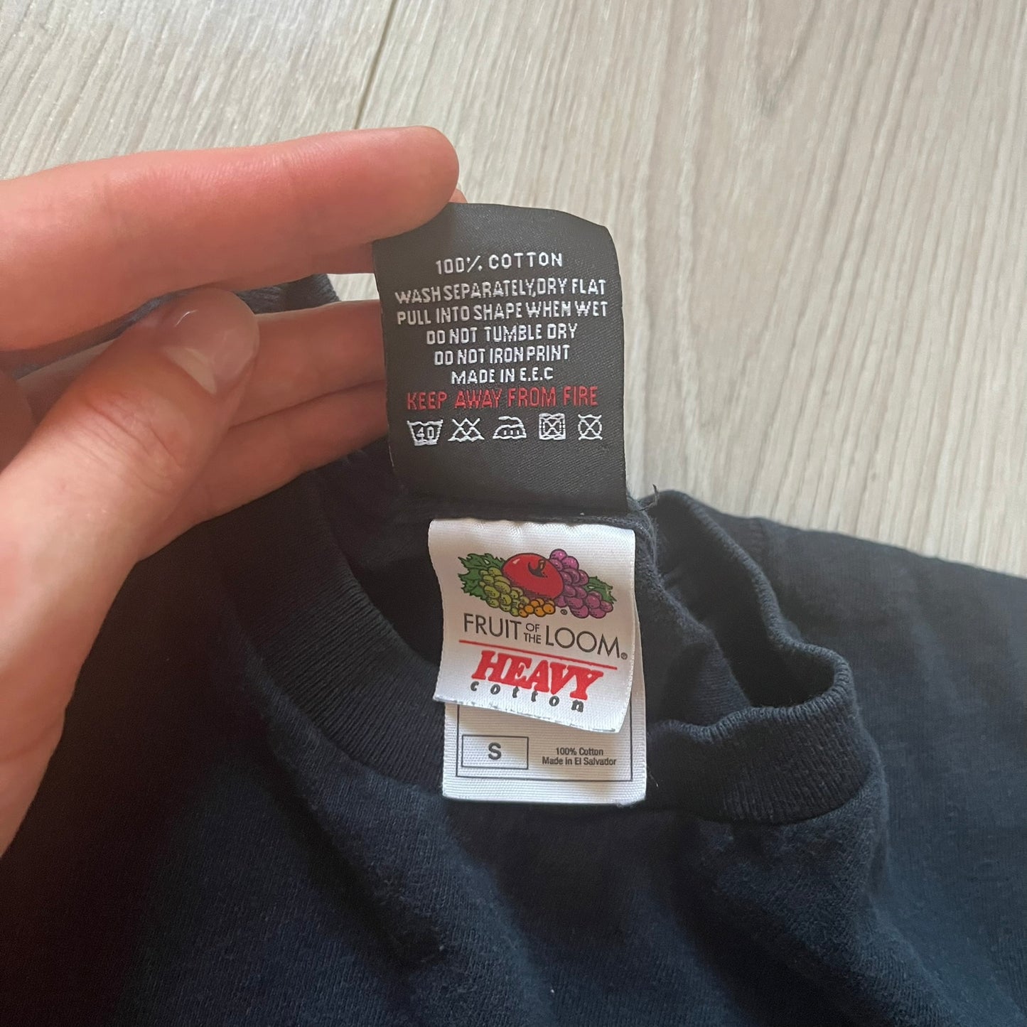 Clothing tag with 'Fruit of the Loom' brand on a dark fabric background
