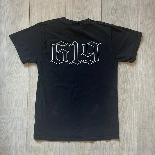 Black t-shirt with '619' logo on a wooden surface