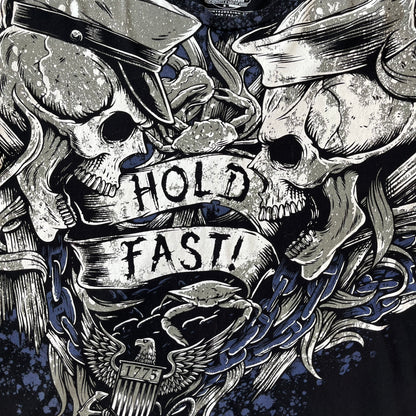 7.62 Design US Navy Black Tee features large front and back graphics in black, white, grey, and navy. The front has two skulls, bones, and US Navy graphics covering most of the shirt. The back has a smaller US Navy logo graphic.
