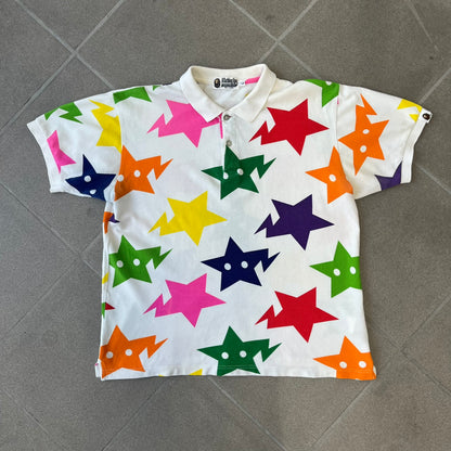 A Bathing Ape 2014 Milo Multicolor Sta Polo is a white, 100% cotton BAPE polo featuring an all-over print of multicolor STA (shooting star) graphics in pink, green, blue, yellow, red (and more), some featuring eyes. It includes branded Bape buttons.