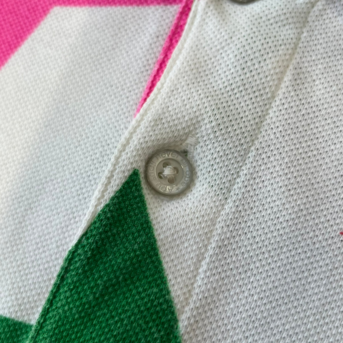 A Bathing Ape 2014 Milo Multicolor Sta Polo is a white, 100% cotton BAPE polo featuring an all-over print of multicolor STA (shooting star) graphics in pink, green, blue, yellow, red (and more), some featuring eyes. It includes branded Bape buttons.