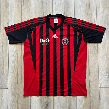 AC Milan Academy x Dolce &amp; Gabbana 2008/09 Home Tee is a black and red striped football shirt with black short sleeves. The chest features AC Milan Academy and Dolce &amp; Gabbana Junior logos on the sides, and a adidas logo in the center. Made with Clima365 technology.
