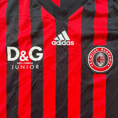 AC Milan Academy x Dolce &amp; Gabbana 2008/09 Home Tee is a black and red striped football shirt with black short sleeves. The chest features AC Milan Academy and Dolce &amp; Gabbana Junior logos on the sides, and a adidas logo in the center. Made with Clima365 technology.
