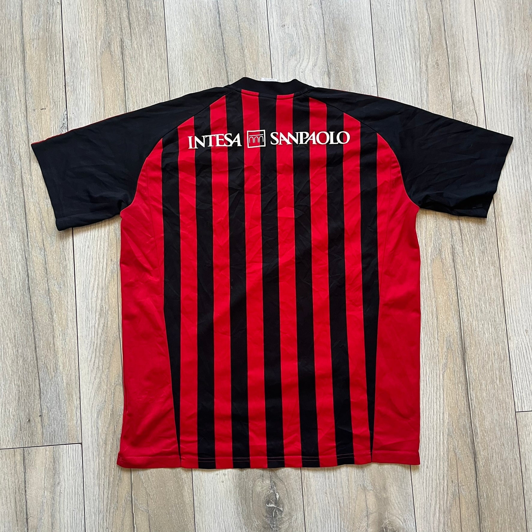 AC Milan Academy x Dolce &amp; Gabbana 2008/09 Home Tee is a black and red striped football shirt with black short sleeves. The chest features AC Milan Academy and Dolce &amp; Gabbana Junior logos on the sides, and a adidas logo in the center. Made with Clima365 technology.
