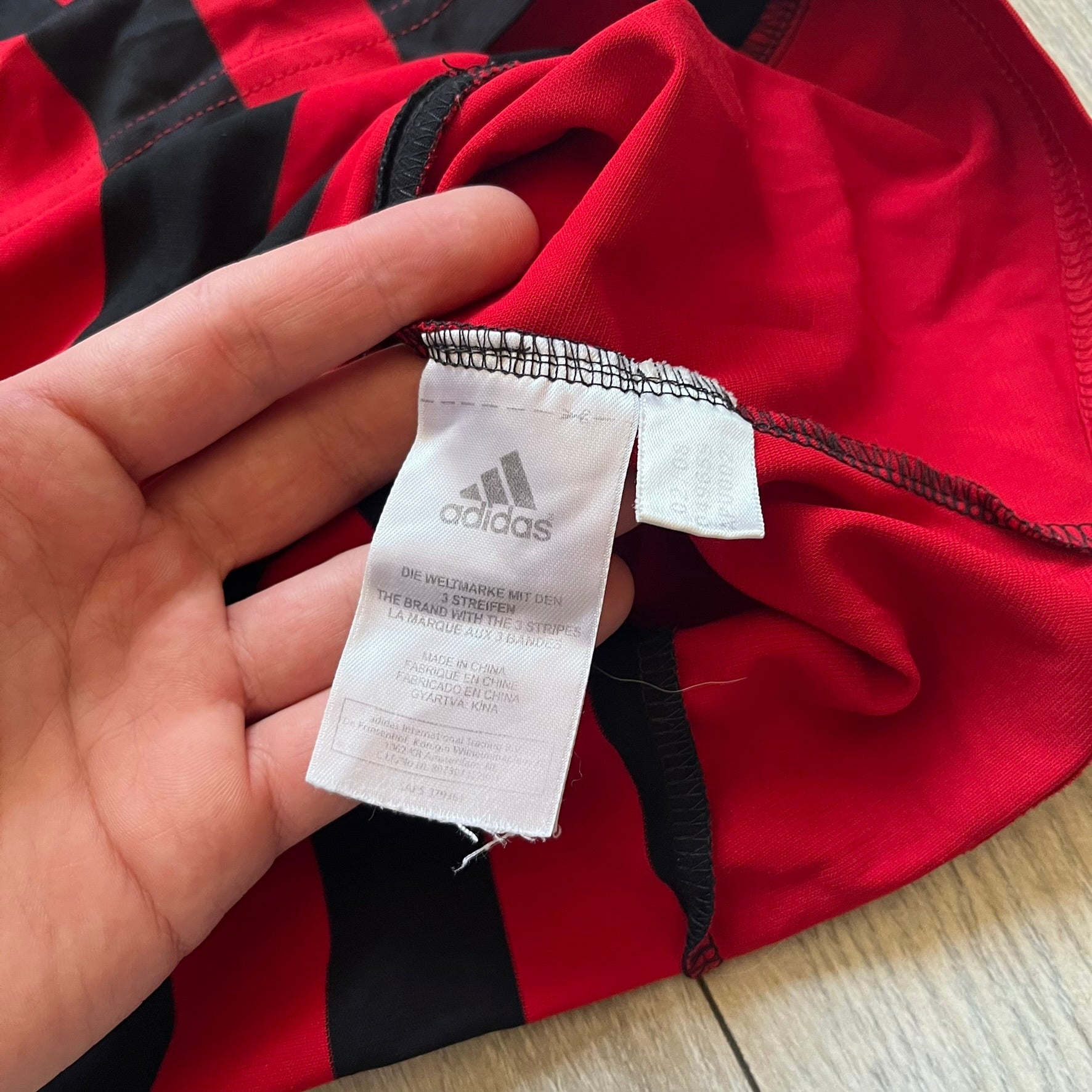 AC Milan Academy x Dolce &amp; Gabbana 2008/09 Home Tee is a black and red striped football shirt with black short sleeves. The chest features AC Milan Academy and Dolce &amp; Gabbana Junior logos on the sides, and a adidas logo in the center. Made with Clima365 technology.
